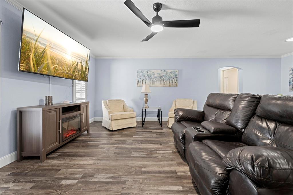 2399 Gallagher Avenue Spring Hill, FL 34606 - Photo 25 of 56 a living room with furniture a flat screen tv and a fireplace
