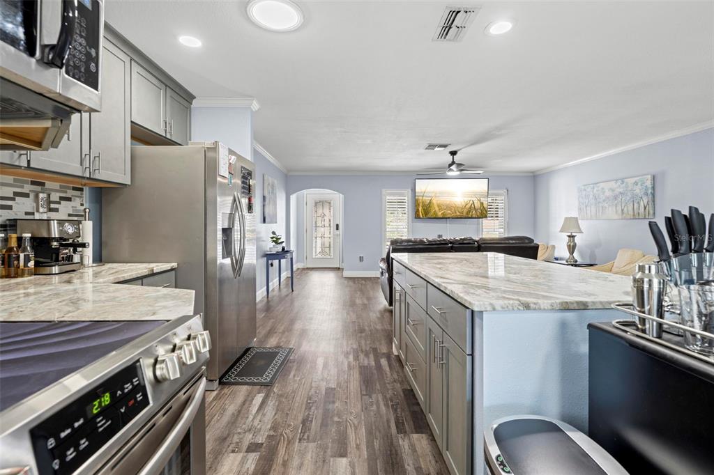 2399 Gallagher Avenue Spring Hill, FL 34606 - Photo 35 of 56 a kitchen with granite countertop a stove and a refrigerator