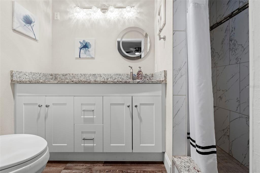 2399 Gallagher Avenue Spring Hill, FL 34606 - Photo 53 of 56 a bathroom with a granite countertop toilet sink and mirror