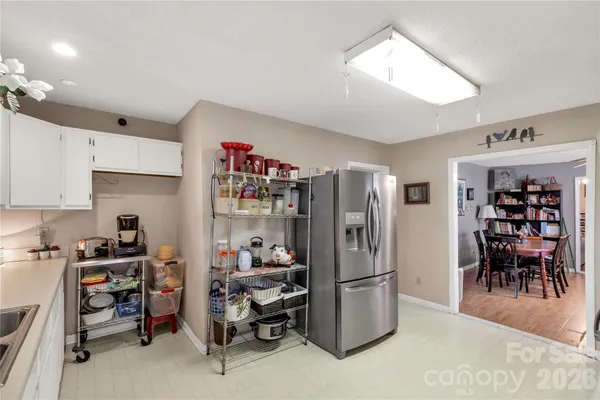 a room with furniture a refrigerator and a dining table