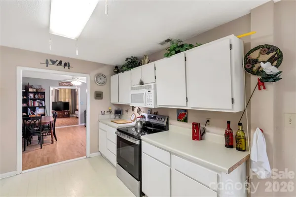 a kitchen with granite countertop a white cabinets a stove and a sink