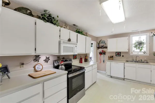 a kitchen with white cabinets and white appliances