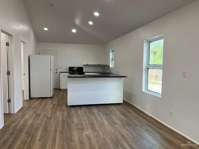 a kitchen with stainless steel appliances a refrigerator and wooden floor