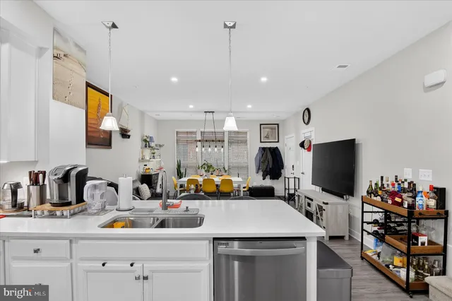 a kitchen with stainless steel appliances a stove a sink dishwasher and a flat screen tv