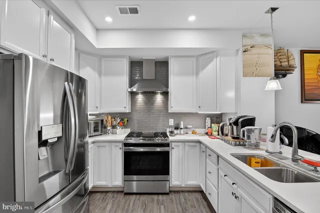 a kitchen with a sink a refrigerator and cabinets