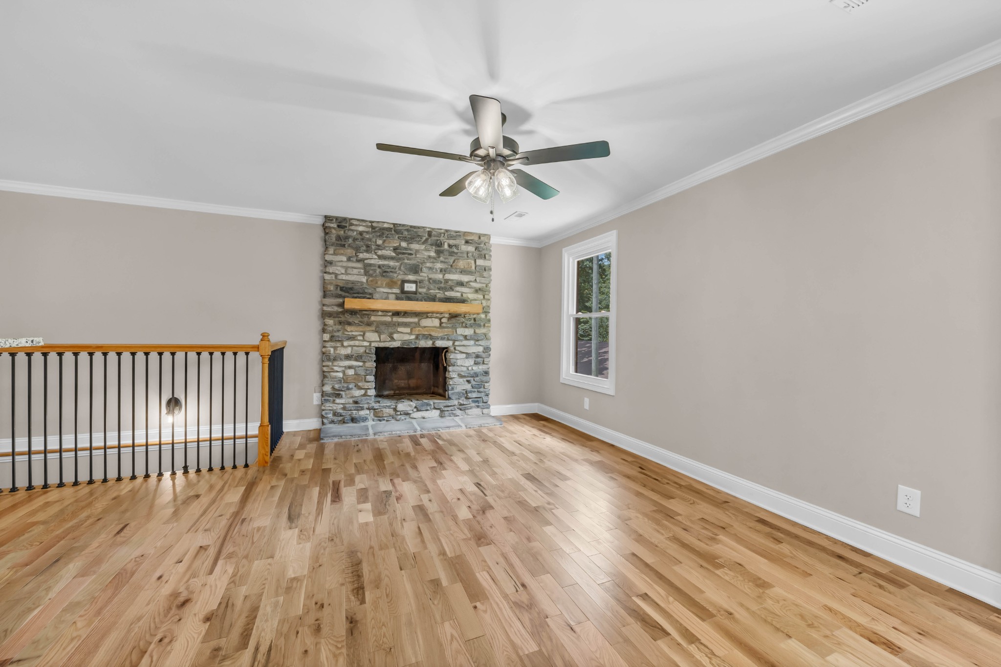 887 Harvey Road Cumberland Furnace, TN 37051 - Photo 9 of 72 a view of a livingroom with a fireplace a ceiling fan and wooden floor