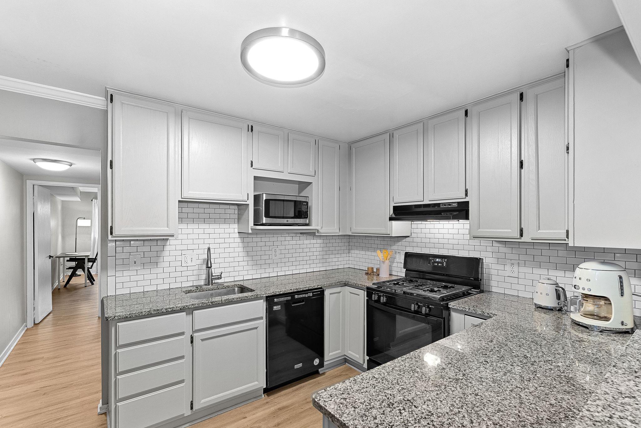 1668 Parkcrest Circle, Unit 100 Reston, VA 20190 - Photo 19 of 34 a kitchen with stainless steel appliances granite countertop a stove sink microwave and cabinets