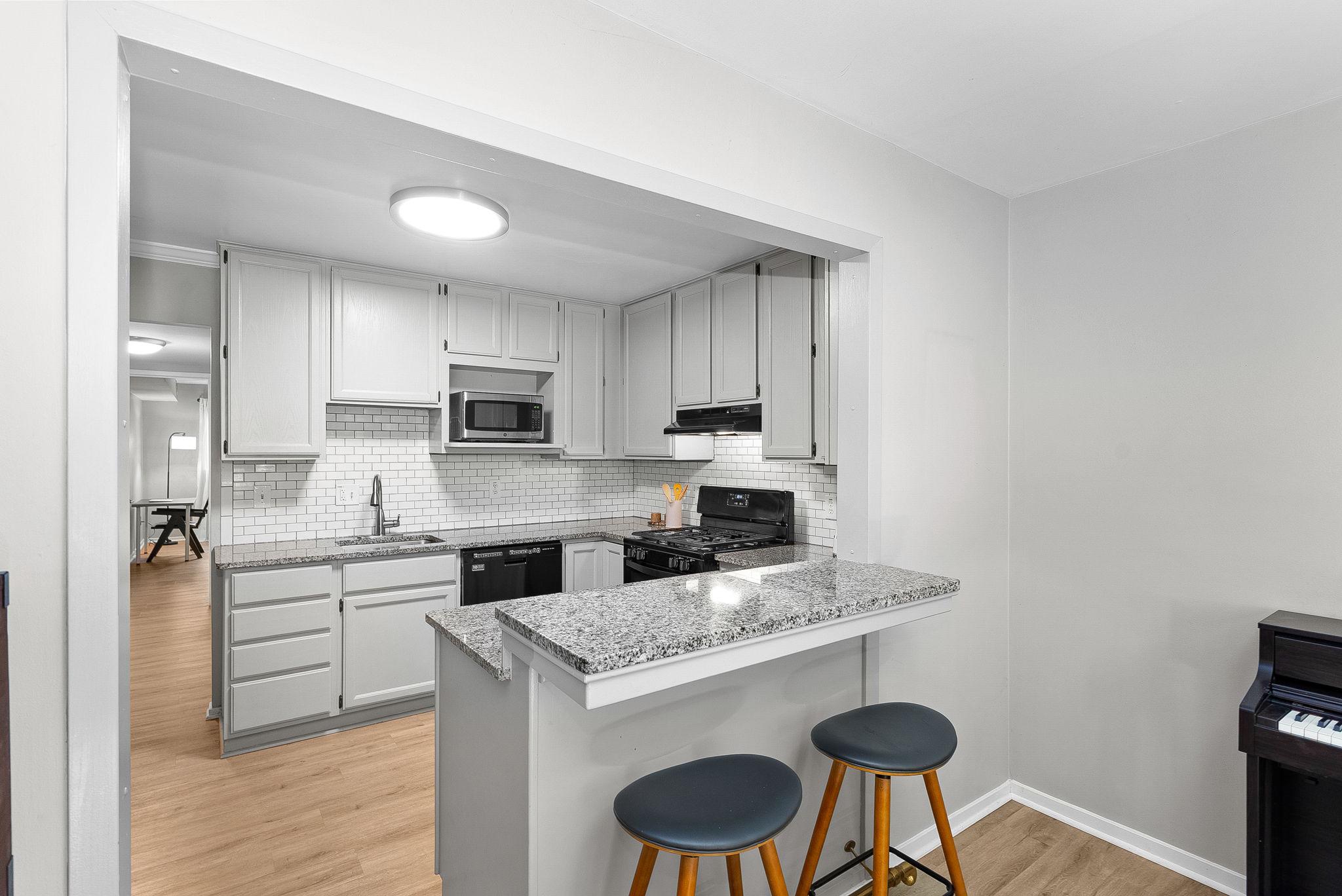 1668 Parkcrest Circle, Unit 100 Reston, VA 20190 - Photo 2 of 34 a kitchen with granite countertop stainless steel appliances a sink and a refrigerator