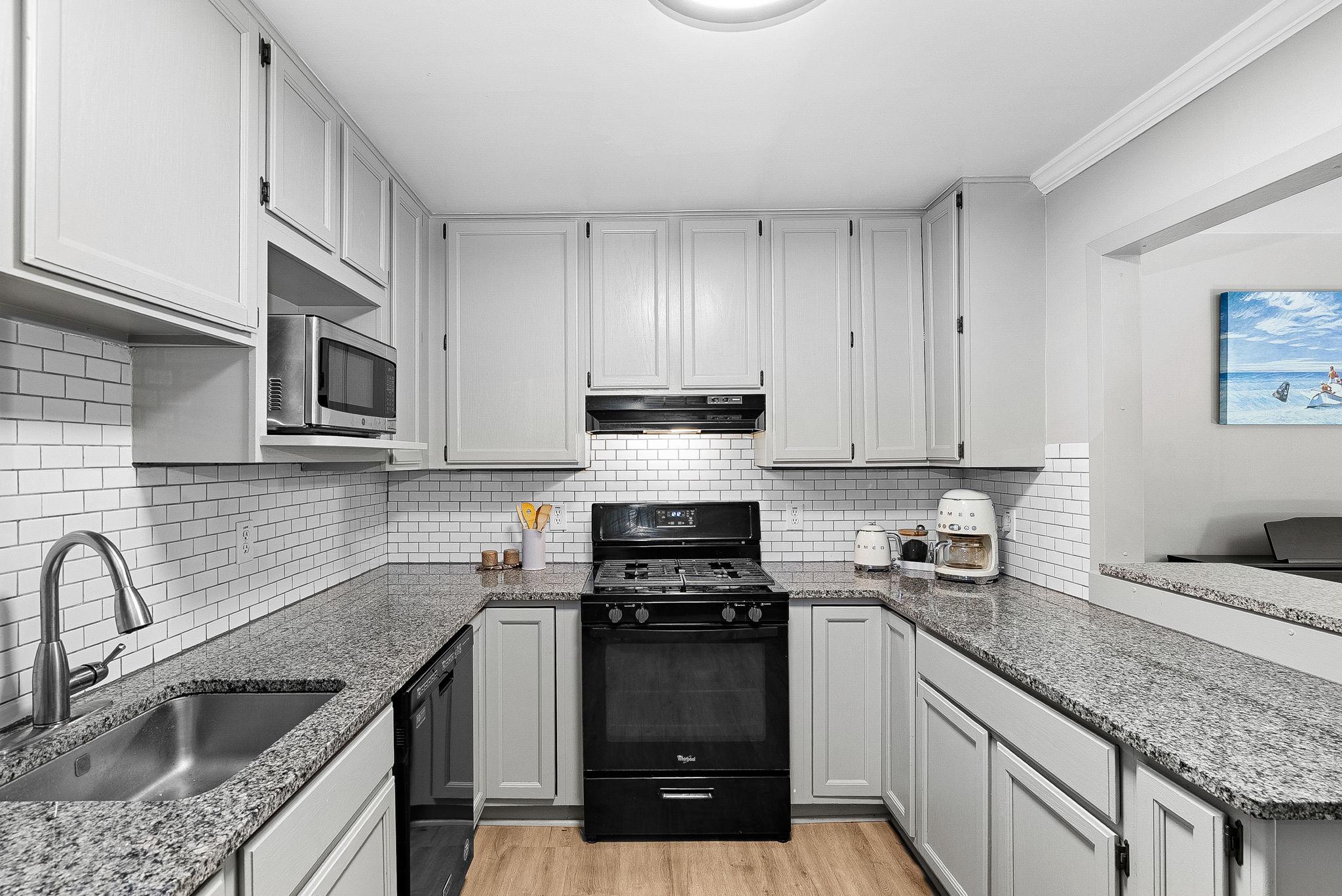 1668 Parkcrest Circle, Unit 100 Reston, VA 20190 - Photo 22 of 34 a kitchen with granite countertop a sink stainless steel appliances and cabinets