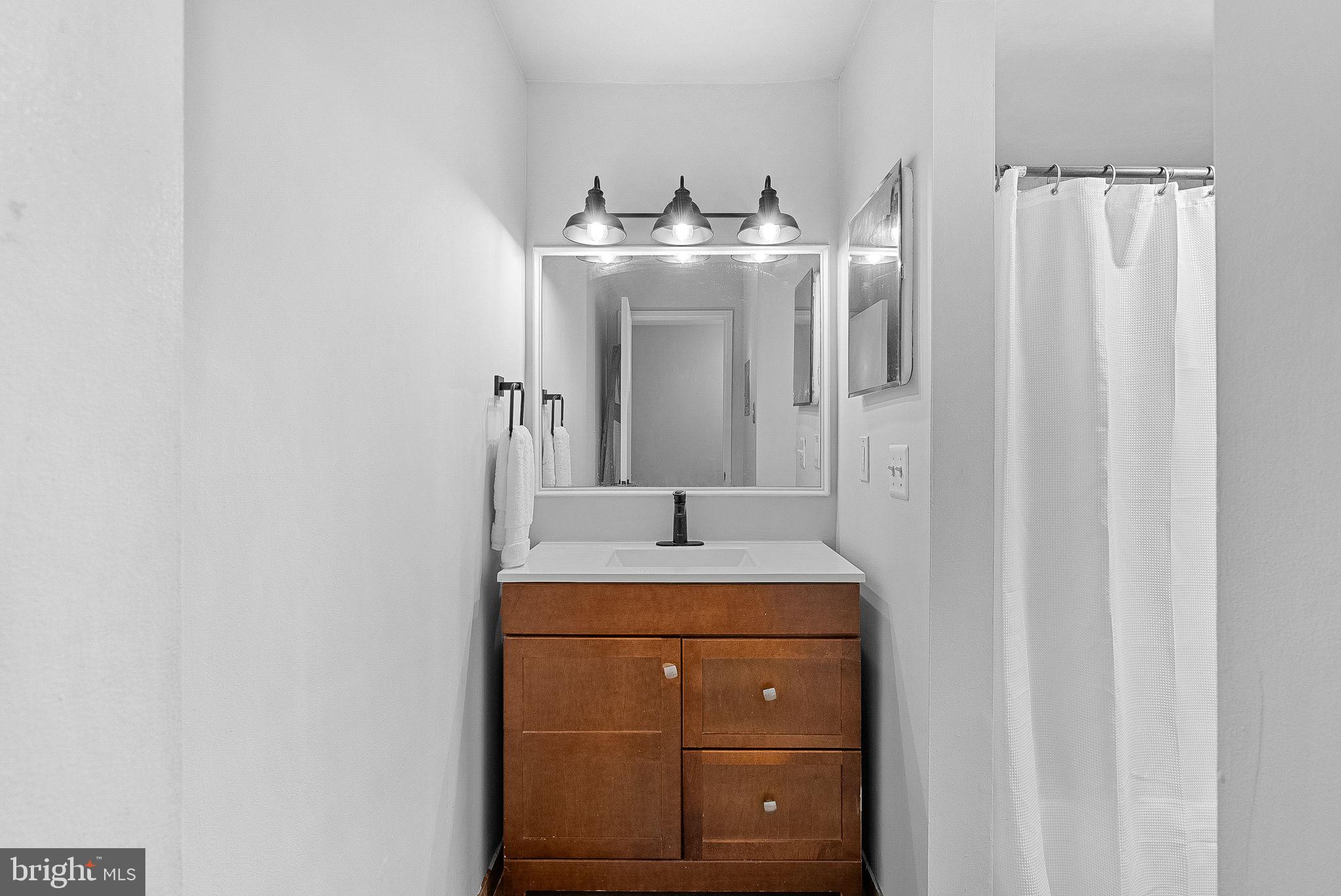 1668 Parkcrest Circle, Unit 100 Reston, VA 20190 - Photo 28 of 34 a bathroom with a sink and a mirror