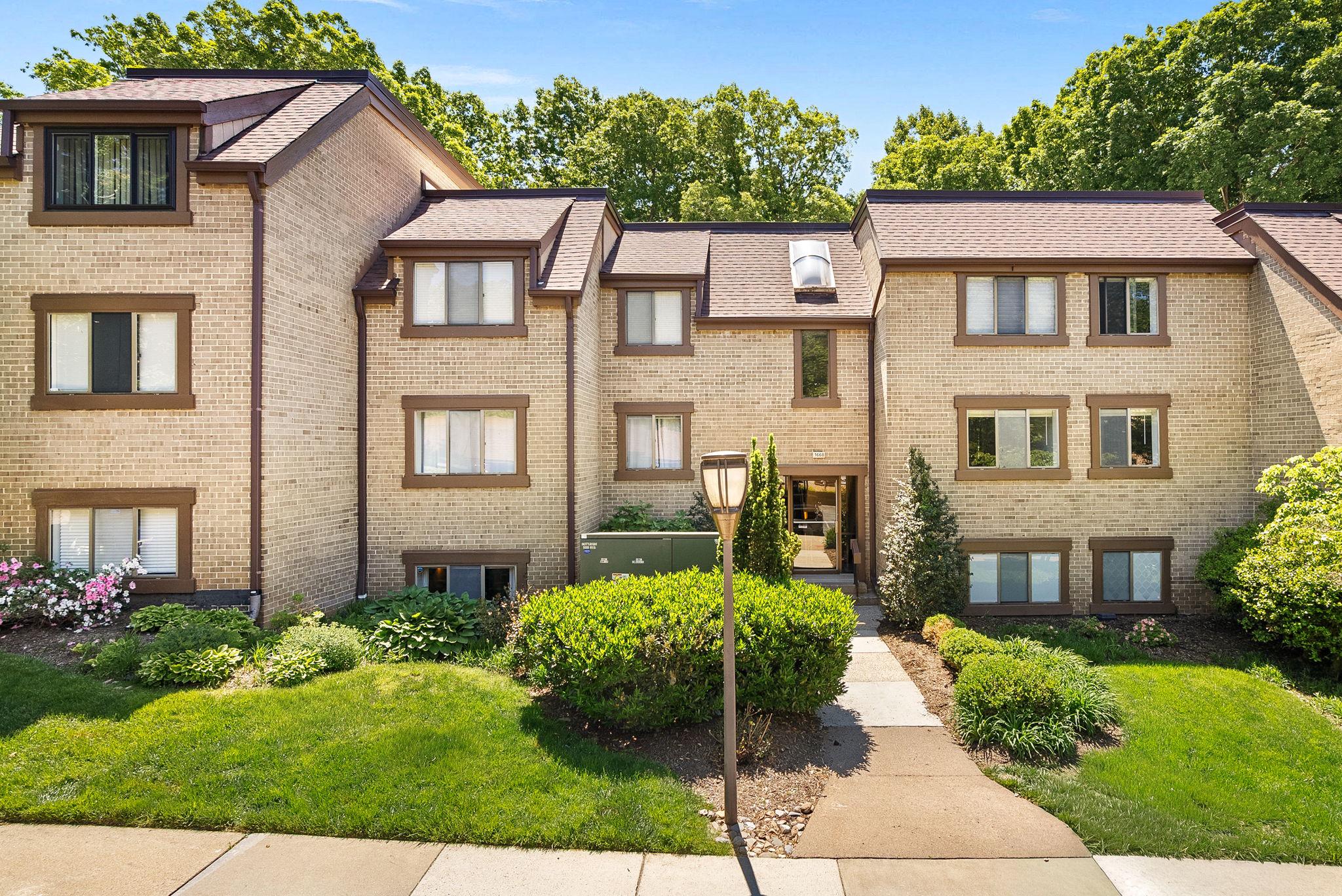 1668 Parkcrest Circle, Unit 100 Reston, VA 20190 - Photo 6 of 34 a front view of a house with a yard and outdoor seating