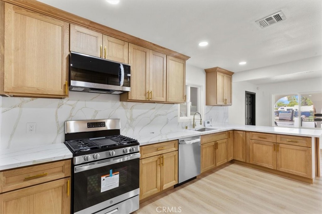 128 North Alessandro Street Hemet, CA 92543 - Photo 12 of 33 a kitchen with stainless steel appliances granite countertop a sink a stove top oven and cabinetry