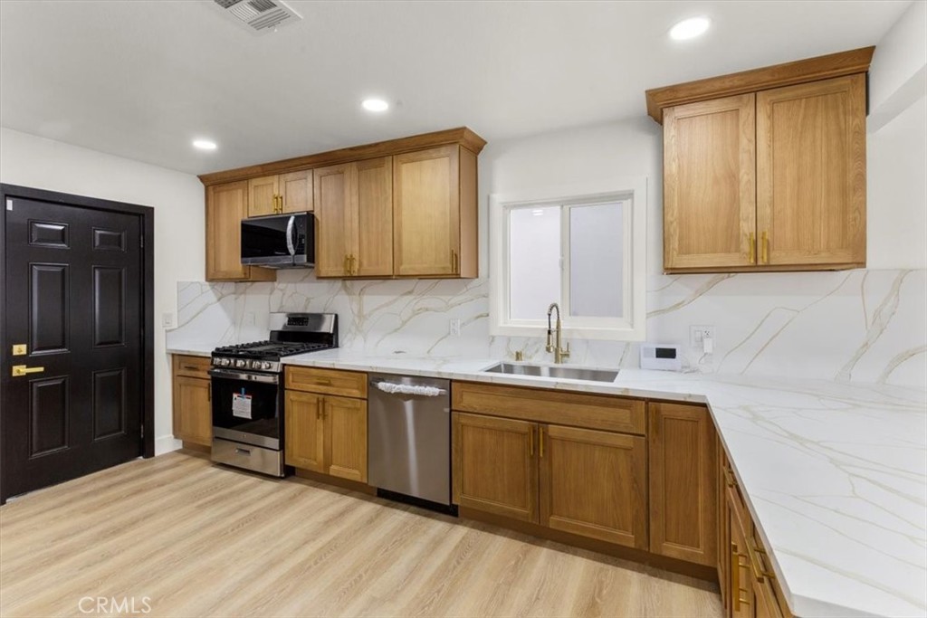 128 North Alessandro Street Hemet, CA 92543 - Photo 10 of 33 a kitchen with stainless steel appliances granite countertop a sink stove and refrigerator