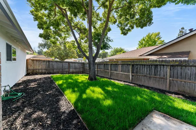 a side view of a house with a wooden fence