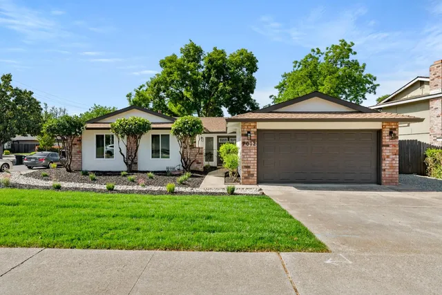 a front view of a house with a yard and garage