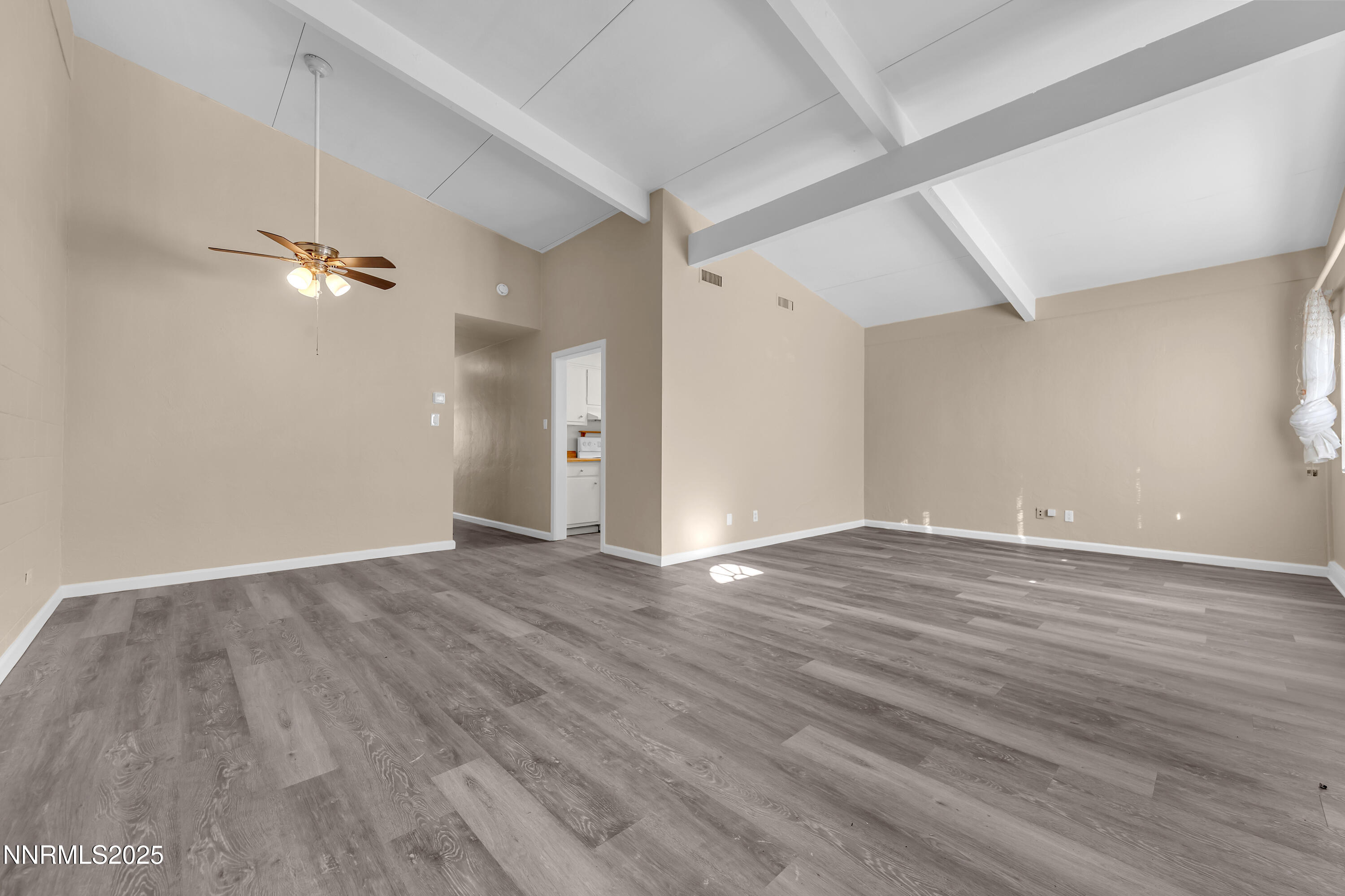 12360 Rocky Mountain Street Reno, NV 89506 - Photo 4 of 29 an empty room with wooden floor and a ceiling fan
