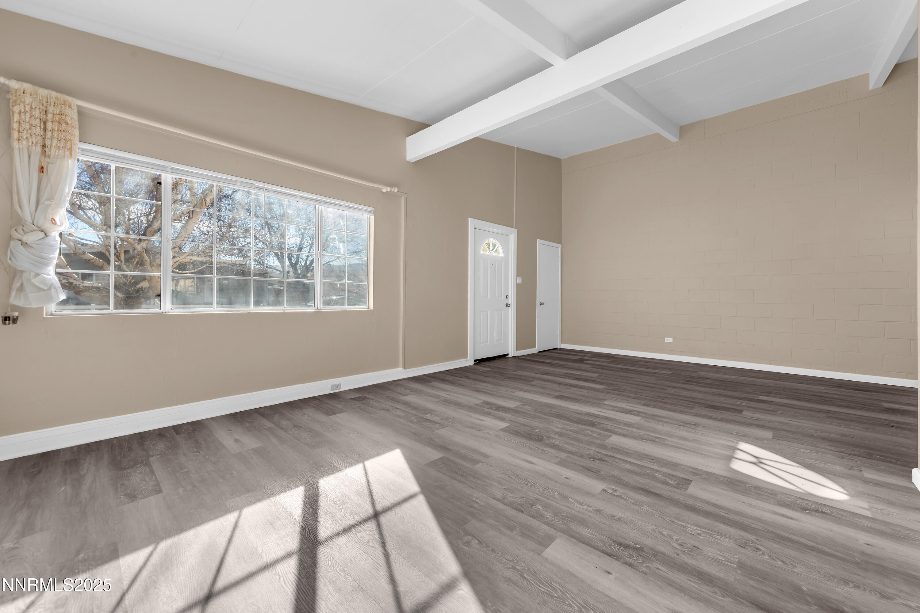 12360 Rocky Mountain Street Reno, NV 89506 - Photo 6 of 29 a view of an empty room with wooden floor and a window