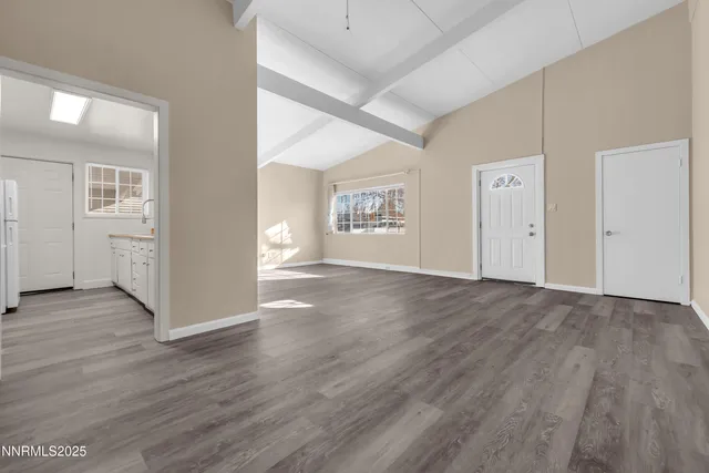 an empty room with wooden floor and white walls