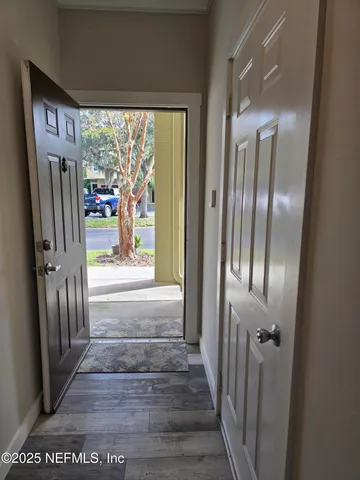 a view of a hallway with wooden floor and door