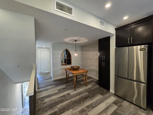 a dining room with stainless steel appliances furniture a refrigerator and kitchen view