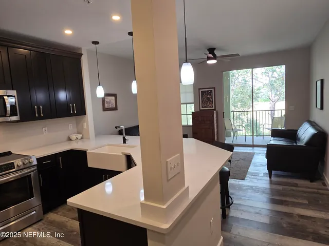 a large kitchen with kitchen island a sink stainless steel appliances and furniture