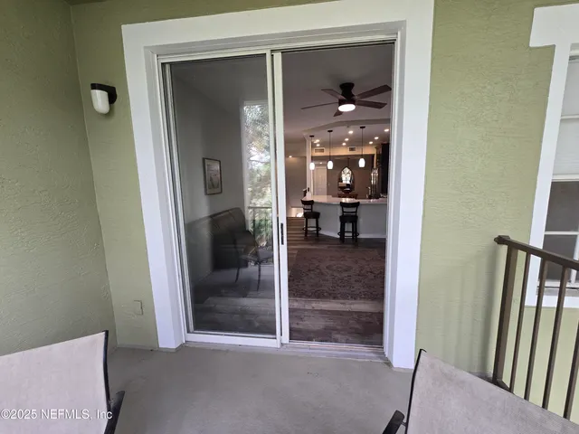 a view of a hallway with livingroom and furniture