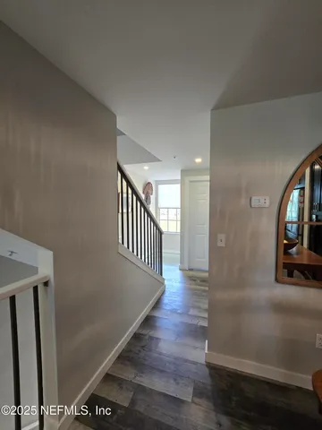 a view of a hallway with wooden floor and staircase