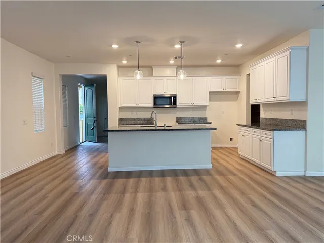 a large kitchen with stainless steel appliances kitchen island a large counter top and a stove top oven