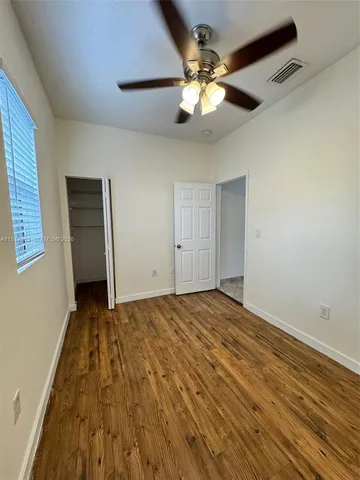 a view of an empty room with a chandelier fan