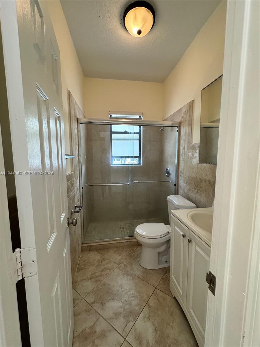 2000 Monroe Street, Unit 11 Hollywood, FL 33020 - Photo 15 of 22 a bathroom with a toilet a sink a shower and mirror