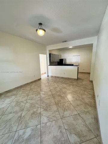 a view of a kitchen with a sink and a refrigerator
