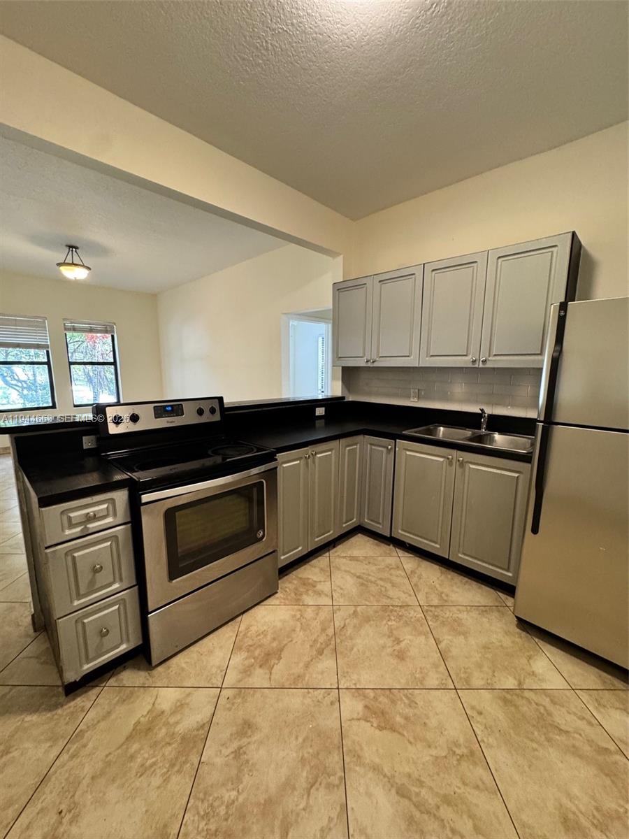 2000 Monroe Street, Unit 11 Hollywood, FL 33020 - Photo 7 of 22 a kitchen with granite countertop a sink and cabinets