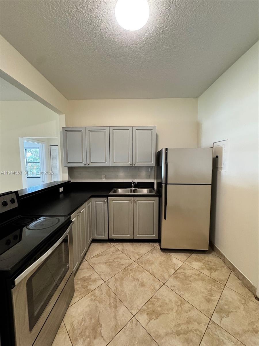 2000 Monroe Street, Unit 11 Hollywood, FL 33020 - Photo 8 of 22 a kitchen with a refrigerator and a stove top oven
