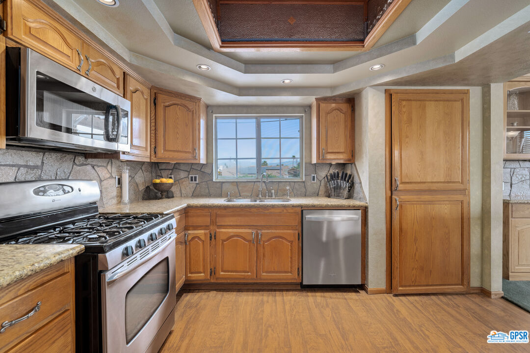 68554 Durango Road Cathedral City, CA 92234 - Photo 11 of 47 a kitchen with stainless steel appliances granite countertop a stove a sink dishwasher and a refrigerator
