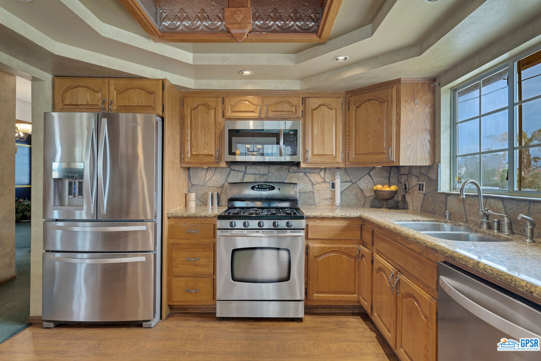 68554 Durango Road Cathedral City, CA 92234 - Photo 7 of 47 a kitchen with a stove refrigerator and a sink