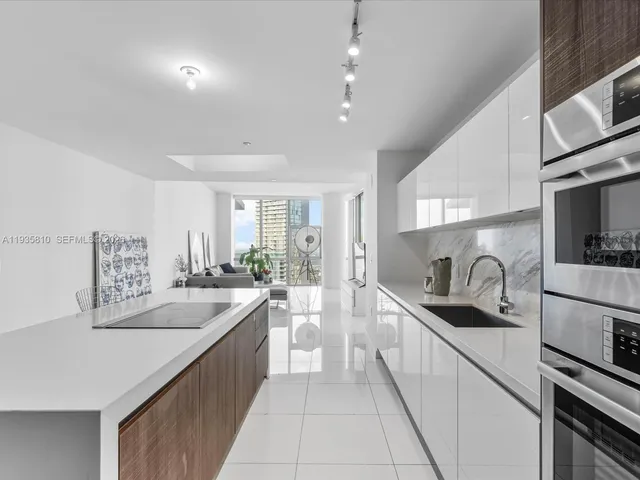 a kitchen with a refrigerator and a stove top oven