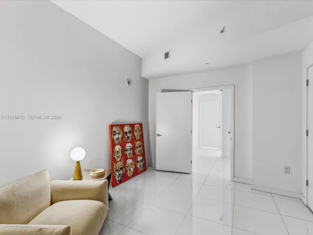 a living room with furniture potted plant and a large window