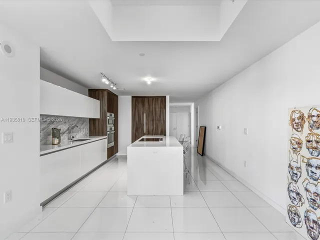 a large white kitchen with a sink a refrigerator and a stove