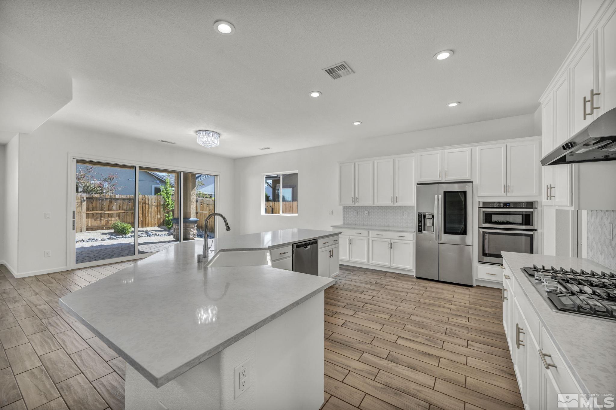 2013 Neviekay Lane Reno, NV 89521 - Photo 21 of 35 a kitchen with stainless steel appliances granite countertop a sink dishwasher stove refrigerator and cabinets with wooden floor