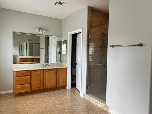 a spacious bathroom with a mirror and a shower