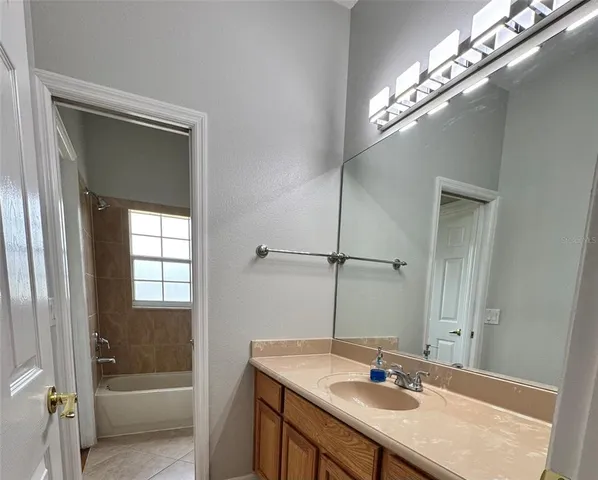 a bathroom with a granite countertop sink a mirror and a bathtub