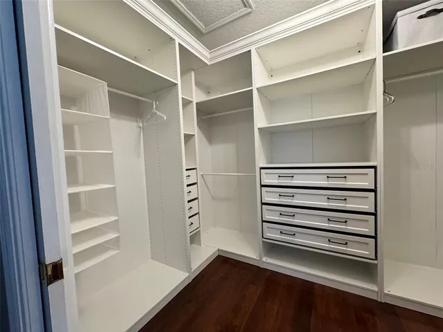 a view of walk in closet with empty racks