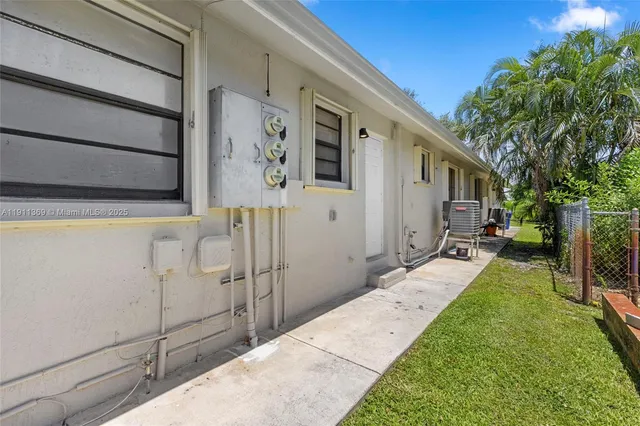 a backyard with table and chairs and potted plants