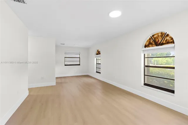 an empty room with a window and cabinet