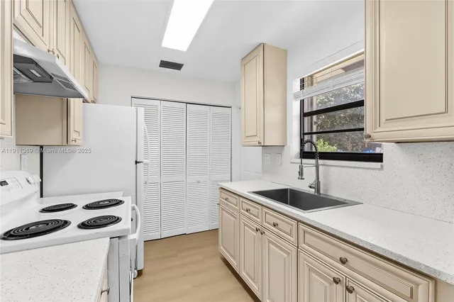 a kitchen with granite countertop a sink stove and cabinets