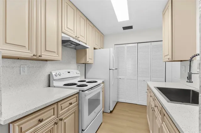a kitchen with stainless steel appliances a sink stove and cabinets