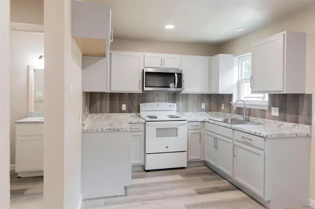 a kitchen with a stove sink and cabinets