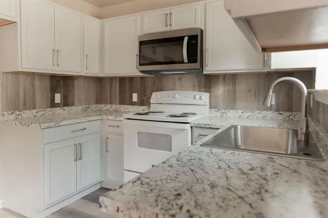 a view of an empty room with wooden floor and closet