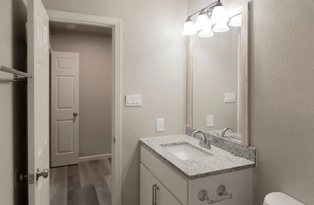 a bathroom with a granite countertop sink toilet and shower