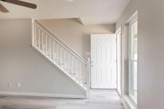 a view of staircase with railing and white walls
